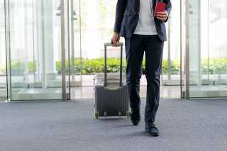 Foto: Mann mit Koffer am Flughafen