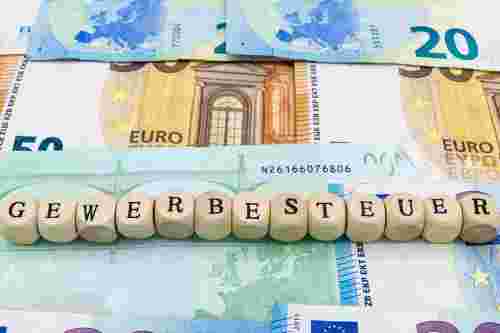 Foto: Aufschrift Gewerbesteuer auf Holzwürfel vor Geldscheinen